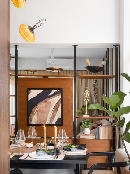The dining space, viewed from the side, showcases the interplay of light and volume. The open-backed shelving partition maintains a connection to the living area while creating a sense of intimacy for meals.