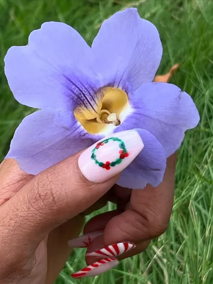 A close-up of the hand-painted Christmas wreath nail art. Even the smallest details are crafted with care to create a perfect holiday manicure.
