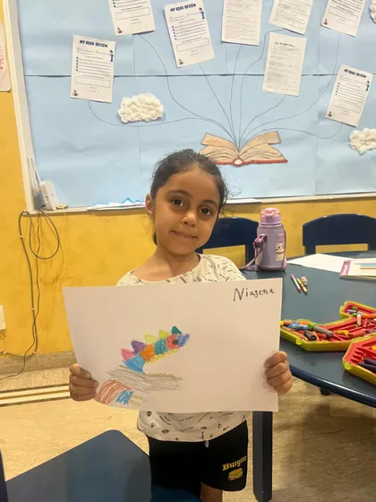 Another wonderful piece of art from our science camp. This student proudly displays her colorful dinosaur drawing for the camera.