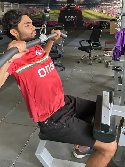 Another player using the lat pulldown machine, a crucial exercise for upper body strength. Our fitness plans are comprehensive.