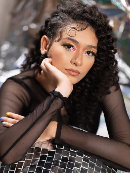 The art of eye contact. This editorial look features a neon graphic liner on a curly-haired model, creating a modern, edgy, and high-fashion aesthetic.