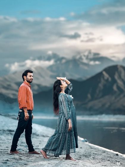 A breathtaking shot of a couple against a mountain and lake backdrop, ideal for a full-page spread in a pre-wedding album.