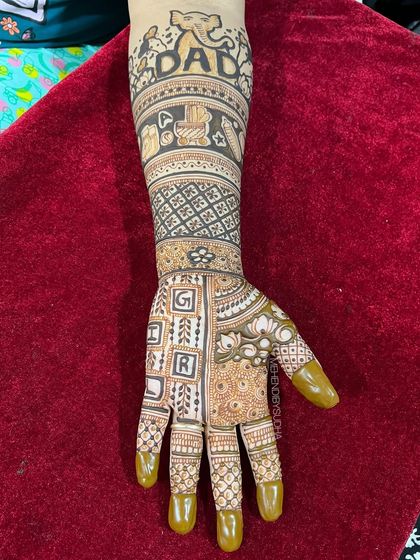 A close-up of the "Dad" arm, featuring an elephant, baby blocks, and the word "GIRL" spelled out, adding a playful guess to the design.