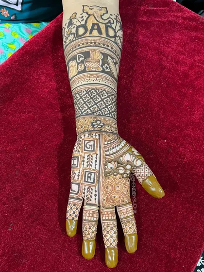 A close-up of the "Dad" arm, featuring an elephant, baby blocks, and the word "GIRL" spelled out, adding a playful guess to the design.