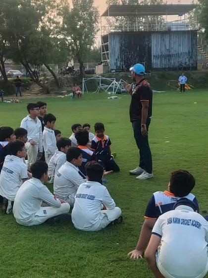 A coach leads a group discussion with our junior players. It is important to develop their thinking about the game, not just their physical skills.