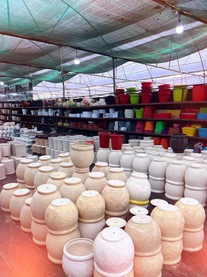 Another view of our pot collection, showing the sheer volume and variety we stock. From large urn-shaped pots to smaller, colorful plastic ones, we have it all.