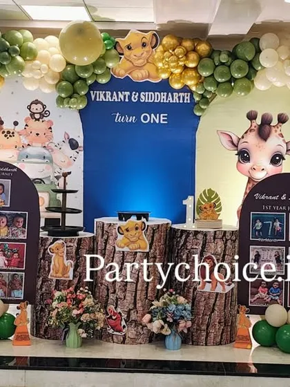 A wide view of the jungle theme stage, showcasing the arrangement of character cutouts, photo displays, and the impressive balloon arch that frames the entire setup.