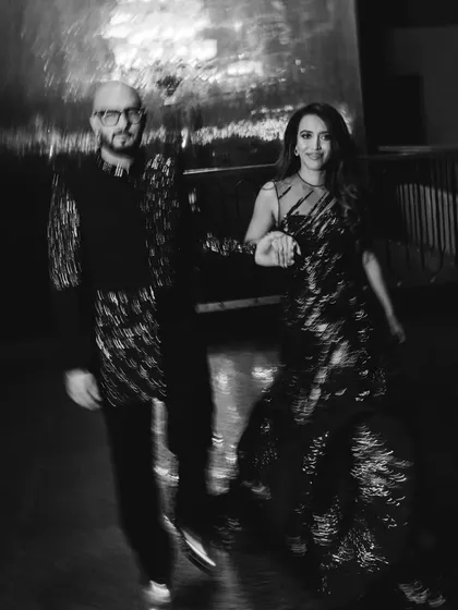 A candid black and white shot of the couple walking together, their movement creating a dynamic and artistic blur.