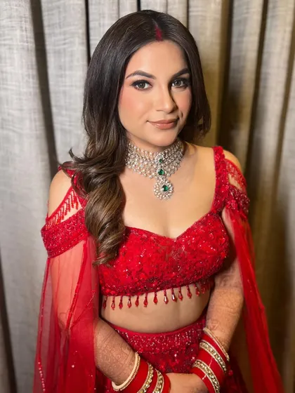 The complete bridal look, with the red lehenga and soft waves, is a perfect combination of tradition and modern elegance.