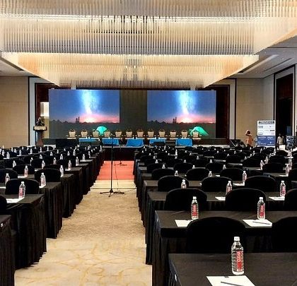 A full view of a grand ballroom configured for a corporate conference, demonstrating my experience with large venues. The sophisticated lighting and dual-screen setup provide a premium experience for attendees and speakers.