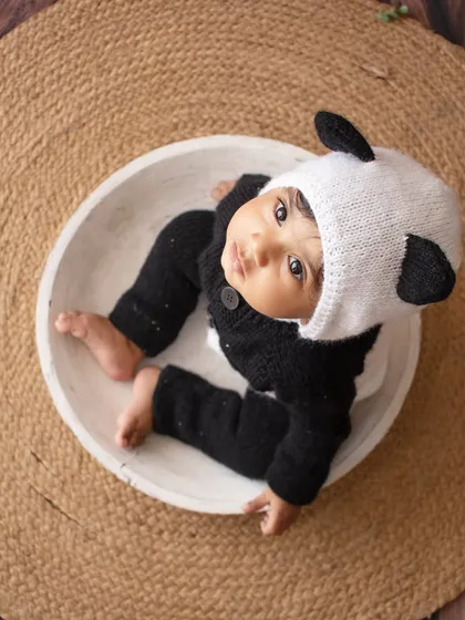 An aerial view of the cutest panda in town, sitting in a white bowl against a rustic jute mat.