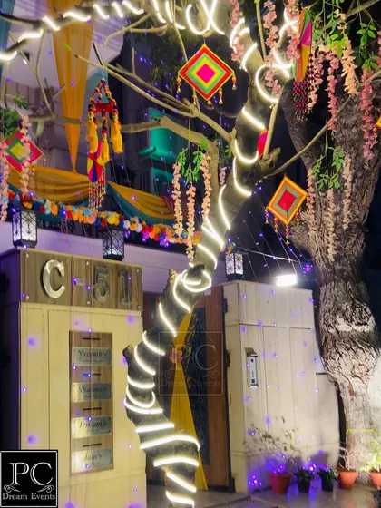 Night-time magic at the wedding home. I wrapped the tree in fairy lights and used colorful hangings to create a magical, illuminated entrance.