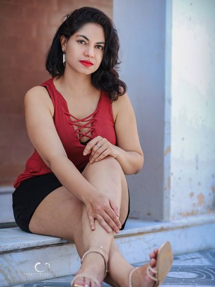 A beautiful and confident portrait. Her direct gaze and relaxed pose create an engaging image that feels both stylish and authentic.