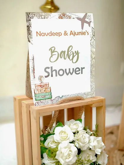 A personalized sign for Navdeep and Ajunie's baby shower. The design incorporates a vintage map and travel motifs to perfectly match their unique "Adventure Begins" theme.