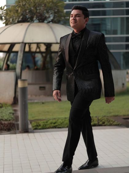 Confidence is the best accessory. A client looking sharp and poised while walking in our black sequin tuxedo. This is the perfect outfit for an engagement party or a formal celebration.