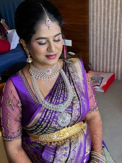 A close-up of Meghana's Seemantham makeup. The eyeshadow is a soft blend of pinks and purples to match her saree, and her skin looks flawless.
