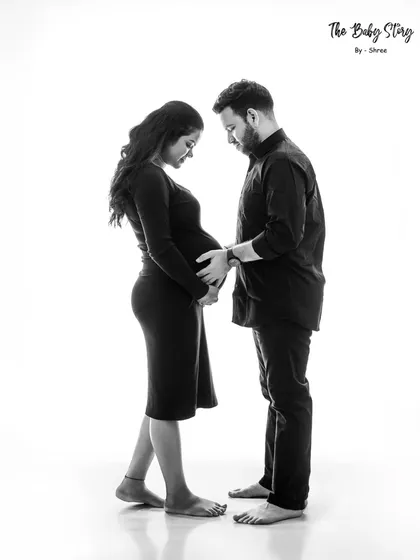 A standing portrait where both partners gently hold the baby bump. The simplicity of the black and white format makes this a powerful image of partnership and anticipation.