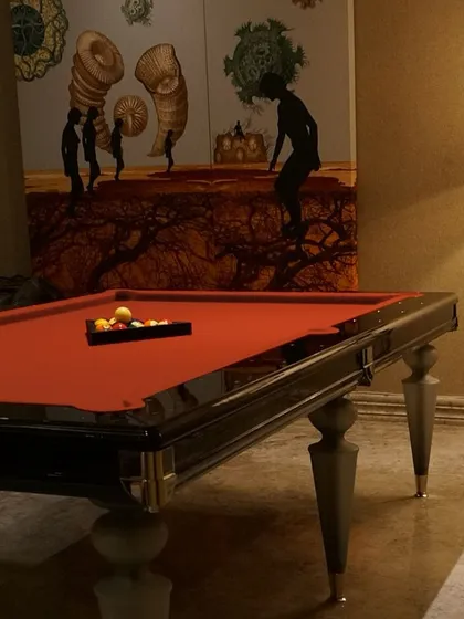A touch of grandeur in every game. This family room, designed in 2009, features a classic pool table that invites leisure. The exquisite artwork and lighting create a space where every detail enhances the room's timeless and impactful design.