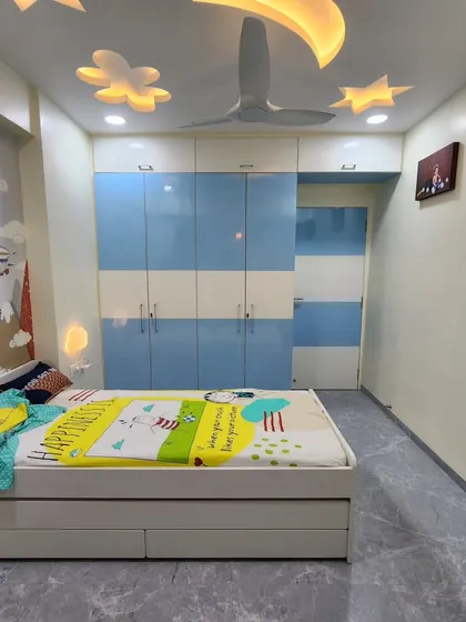 The room features a large wardrobe with a blue and white striped pattern, providing ample storage for clothes and toys.