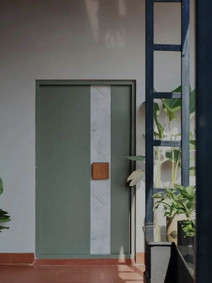 Another perspective of the unique entrance door, viewed through the structure of the building. This framing effect highlights the door as a piece of art and showcases the interplay of light, shadow, and structure that I love to create in my projects.