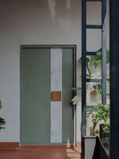 A different perspective of the sage green and marble door, viewed through a structural metal frame. This composition of layers, textures, and indoor plants is a small example of how we approach creating visually interesting spaces.