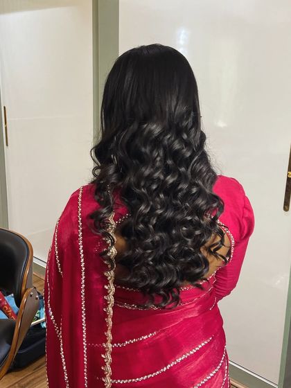 Another view of the beautiful red saree and curly hairstyle, a combination that is both modern and timeless.