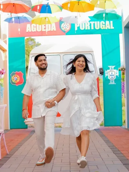 A fun, dynamic shot of the couple walking through a colorful, Portugal-themed alleyway. This set offers a unique and vibrant background for a pre-wedding shoot that feels like a European holiday.
