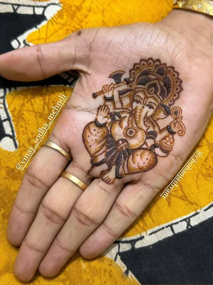 A minimalist yet detailed portrait of Lord Ganesha in the center of the palm. This is a great option for guests who want a festive touch without a full-hand design.