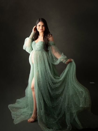 A confident and glamorous pose in a beautiful, pearl-studded green gown with a thigh-high slit.