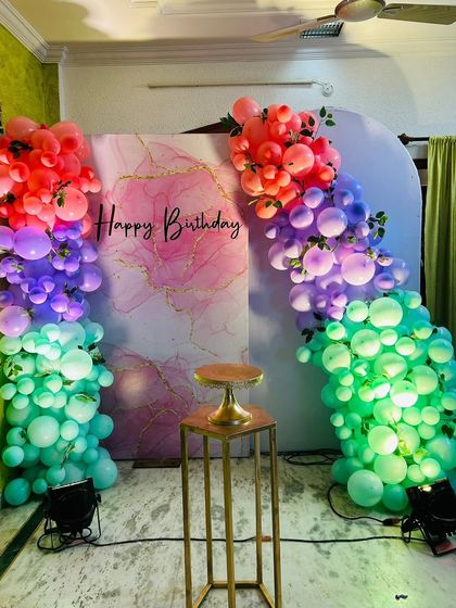 A full view of the marble-print backdrop and rainbow balloon decor, showing the use of lighting to enhance the colors.