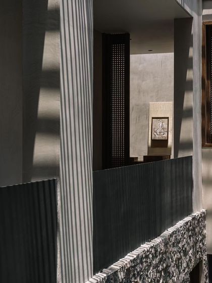 The architectural details of the courtyard, with its clean lines, natural textures, and the constant presence of light and shadow.