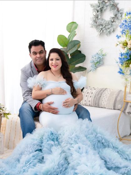 A beautiful portrait of a couple enjoying their maternity session. The soft lighting and her dreamy blue gown create a romantic and peaceful atmosphere.