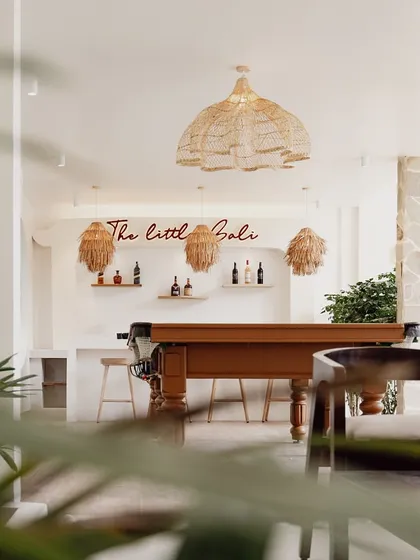 A glimpse into "The Little Bali" bar and entertainment room, where natural wood, stone accents, and playful lighting create a relaxed and social atmosphere.