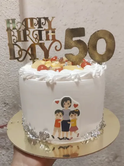 A simple yet sweet 50th birthday cake. This fruit cake is topped with fresh fruits and a custom topper, perfect for a family celebration.