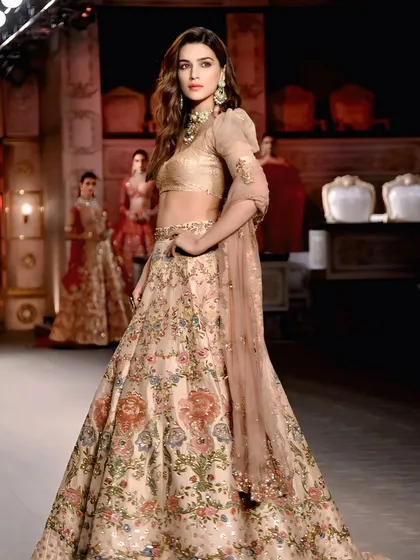 A three-quarter shot of Kriti Sanon on the ramp, with other models in the background. This gives context to the collection and the overall theme of the fashion show.