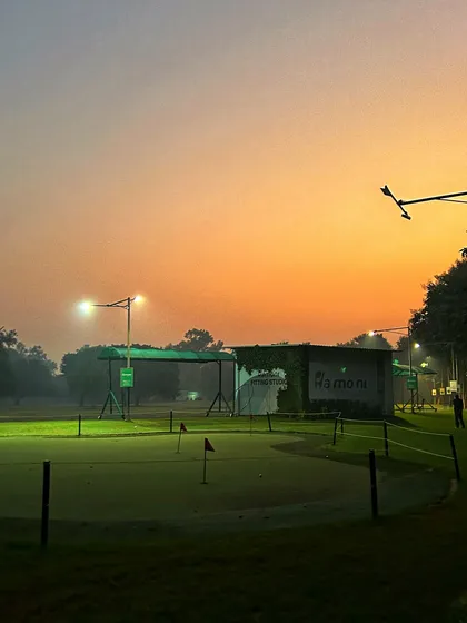 The putting green is illuminated at dusk, providing a beautiful and serene spot for evening practice.