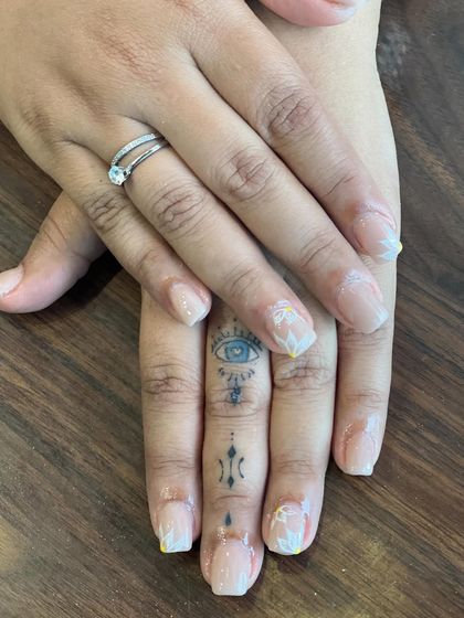 This image captures the subtle beauty of our hand-painted floral nail art. The delicate white flowers add a soft, feminine touch to the otherwise clean and natural-looking manicure.