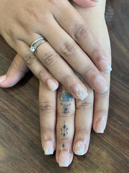 This image captures the subtle beauty of our hand-painted floral nail art. The delicate white flowers add a soft, feminine touch to the otherwise clean and natural-looking manicure.