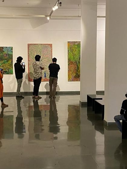 More visitors enjoying the vibrant, colorful paintings by Devu Nenmara.