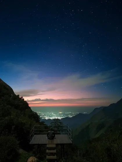 A stunning night view from a viewpoint near our Munnar camp, with city lights twinkling far below under a star filled sky.