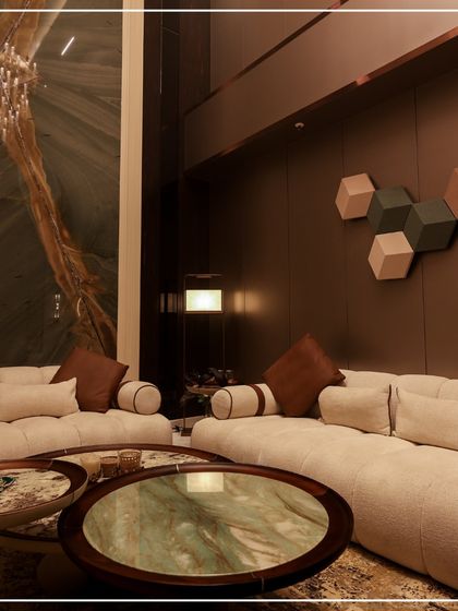 This living room features a stunning double-height ceiling with a massive green marble accent wall. The neutral, low-profile sofas keep the focus on the dramatic architecture and the beautiful textures.