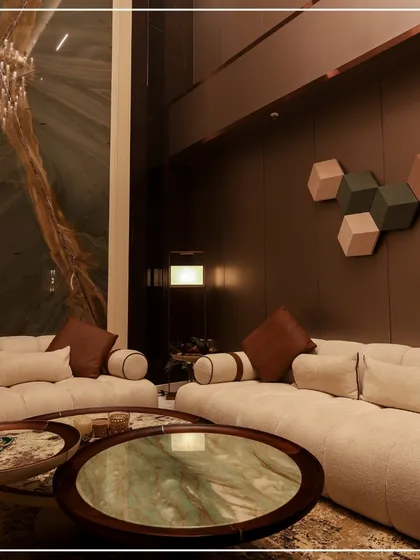 This living room features a stunning double-height ceiling with a massive green marble accent wall. The neutral, low-profile sofas keep the focus on the dramatic architecture and the beautiful textures.