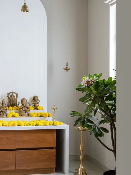 A sacred space designed with modern simplicity. This mandir corner, featuring a clean white arch and warm wood console, shows how we integrate spiritual elements into the home with reverence and contemporary elegance.