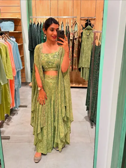 A stylish green co-ord set with a cape, offering a contemporary and fashionable choice for festive celebrations.