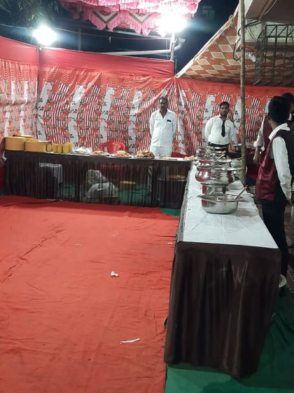 Here is our buffet station ready for service at an outdoor event. We set up on a carpeted area with multiple tables to hold starters, main courses, and desserts, with my team ready to assist.