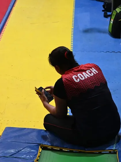 A coach takes a moment to review notes, always planning and strategizing for her students' success.