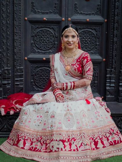 This bride's look is rooted in tradition and enhanced with elegance. Her white and red lehenga is complemented by makeup that feels as timeless as her vows.