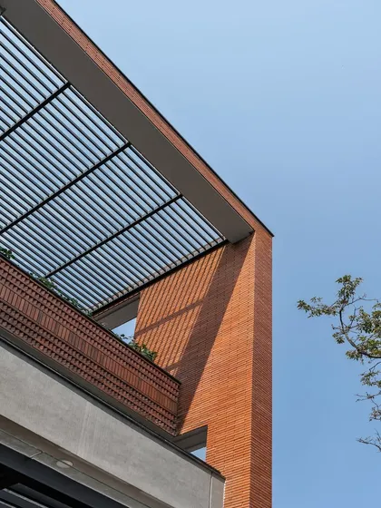 Different angles of the brick facade and pergola, showing how the design captures the sky. These framed views are intentionally designed to connect the residents with the open sky and surrounding nature.