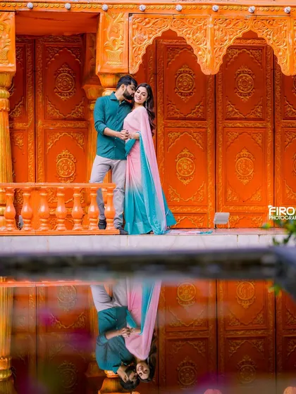 I love blending tradition with a modern, artistic eye. Here, the vibrant colors of the couple's outfits and the stunning architecture are doubled in the water's reflection, creating a perfectly symmetrical and colorful pre-wedding portrait.