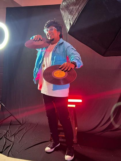 A behind-the-scenes look at a photoshoot with vinyl records and studio lighting. This captures my dedication to the craft and my dream of chasing the light.